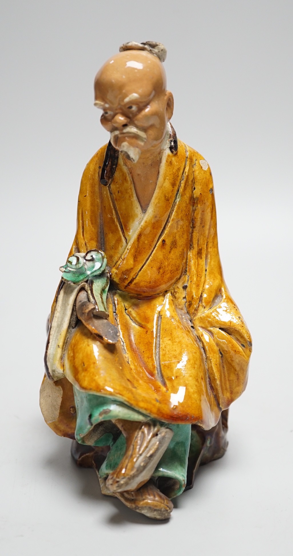 A Chinese Shiwan figure of a sage, possibly 18th century, 19cms high